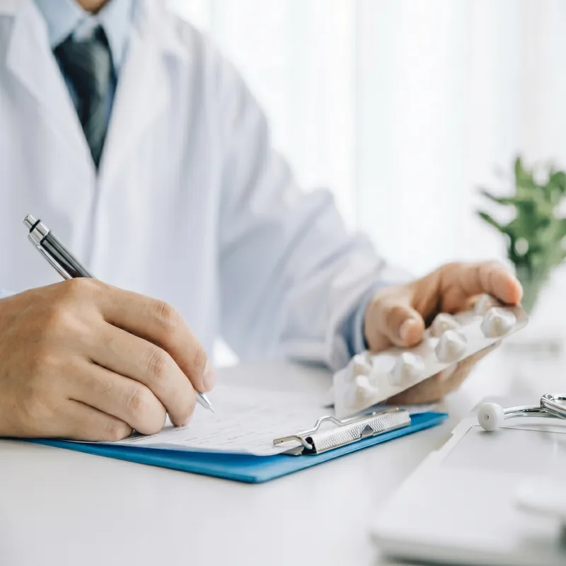 Physician reviewing medication notes on a clipboard